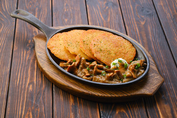 Fried chanterelles, honey mushrooms and potato pancakes with creamy sauce