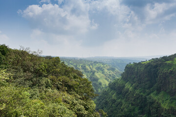 Obraz premium Panoramic view of a lush green valley on winter day at Satara, India