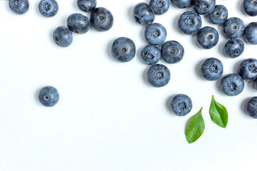 Blueberries background. Fresh juicy blueberries with green leaves on white background. Flat lay top view copy space. Healthy berry, organic food, antioxidant, vitamin, blue food. Blueberry frame