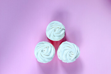 Top view on homemade white marshmallow pastille on light pink background