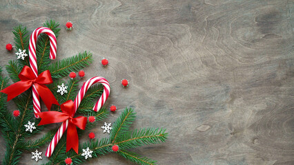 Christmas lollipop with red bow, white snowflakes, red balls and christmas tree branch on brown...