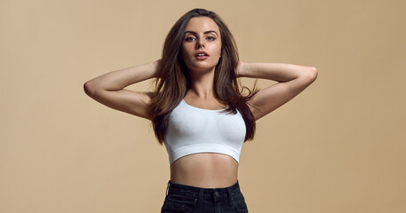 Obraz premium Portrait of Beautiful model posing on beige color background with copy space