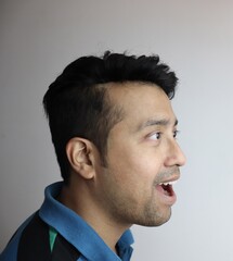 Obraz premium omg. right side face of an asian man with amazed expression looking towards a copy space with white background.