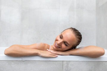 Young woman relaxing in bath smile with bath foam.