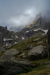 vue sur pic de montagne avec des nuages bas et lumière du soleil filtré par les nuages 