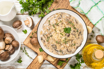 Champignons in cream sauce at white table.