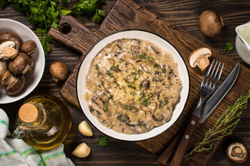 Champignons in cream sauce at white table.