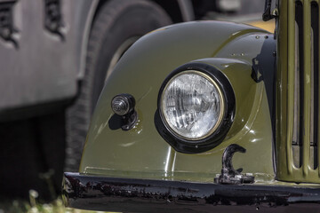 Headlight close-up. Part of the car. Transport background. Retro cars. Military equipment. Machine eyes. Car headlights. Exhibition of old cars.