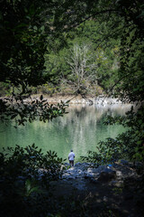 Hombre pescando en un río en medio del bosque