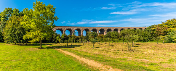 A panorama view across a park towards the Chappel Viaduct near Colchester, UK in the summertime