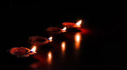 earthen oil lamp lit on the occasion of deepavali, a hindu festival of light with selective focus on lamp and background and foreground blur