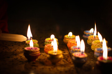 earthen diya lamp lighting with candles on the occasion of diwali and sandhi pujo
