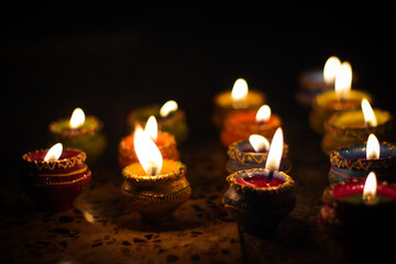 earthen diya lamp lighting with candles on the occasion of diwali and sandhi pujo