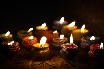 earthen diya lamp lighting with candles on the occasion of diwali and sandhi pujo