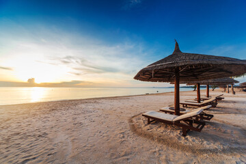 sun loungers and parasols on sandy beach