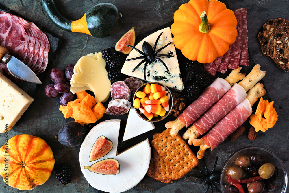 Poster halloween theme charcuterie platter. top view table scene against a black stone background. assorted