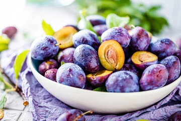 close-up view of bowl with fresh plums on table