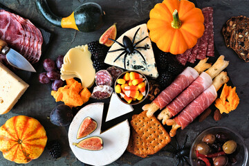 Halloween theme charcuterie platter. Top view table scene against a black stone background....