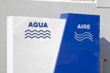 muro con señal indicando agua y aire, puesto de gasolina, auto servicio