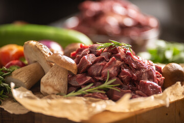Sliced deer meat prepared for stew of game forest mushrooms herbs and vegetables