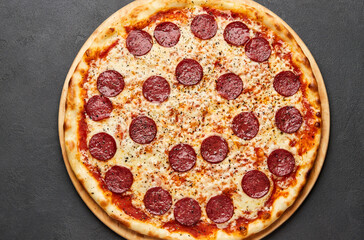 Delicious Italian Pizza pepperoni with mozzarella cheese and salami on dark background