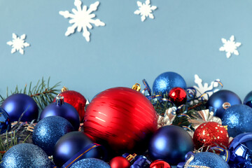 Christmas balloons-red and blue-with festive tinsel on a blue background with snowflakes, side view