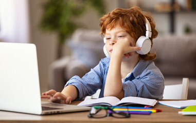 Tired  ginger boy  during remote education.