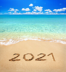 2021 written on sandy beach