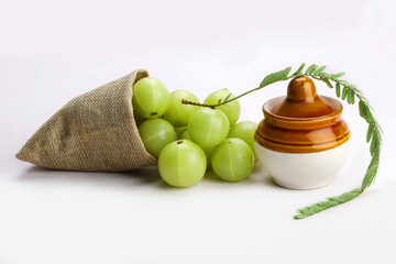 Indian gooseberry or amla in white background with jar.
