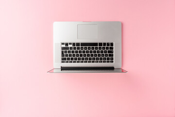 Overhead shot of laptop on pink background with copyspace. Office desktop. Flat lay