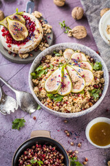 top view of gourmet dish with Figs fruits, nuts, honey, couscous and pomegranate seeds on table