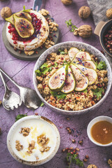 top view of gourmet dish with Figs fruits, nuts, honey, couscous and pomegranate seeds on table