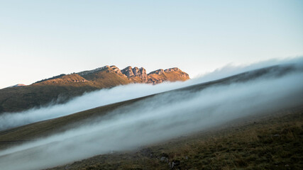 Niebla sobre braña con montaña de fondo
