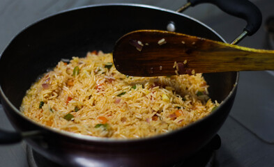 fried rice pulao cooking in a frying pan