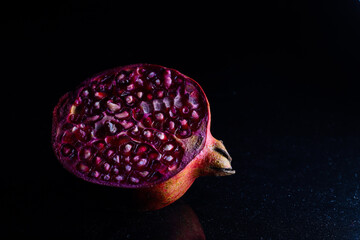 close up photo of cut pomegranate in dark background