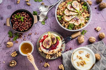 top view of gourmet dish with Figs fruits, nuts, honey, couscous and pomegranate seeds on table