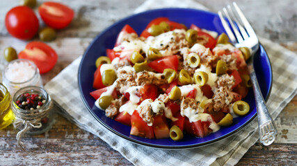 Delicious salad with tuna and olives on a plate. Healthy food concept.