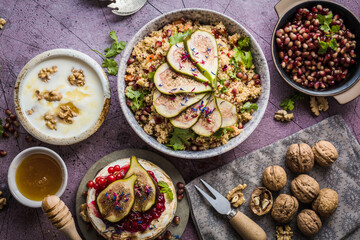 top view of gourmet dish with Figs fruits, nuts, honey, couscous and pomegranate seeds on table