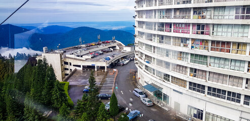 cable car at genting highlands, malaysia in a foggy weather with hotel visible from inside cable car