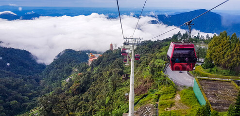 cable car at genting highlands, malaysia in a foggy weather with green grass visible from inside...
