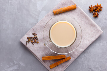 Fototapeta na wymiar Masala chai tea. Traditional indian drink - masala tea with spices on gray background. Copy space. Top view