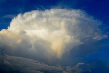 in a large white interesting form the cloud is seen about the approach of rain in the sky above the blue color