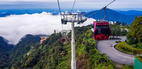 cable car at genting highlands, malaysia in a foggy weather with green grass visible from inside cable car - Powered by Adobe