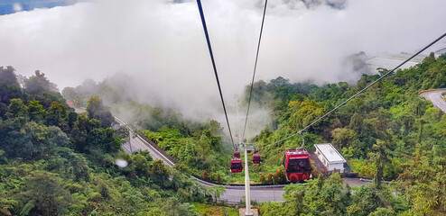 cable car at genting highlands, malaysia in a foggy weather with green grass visible from inside cable car © Arindam