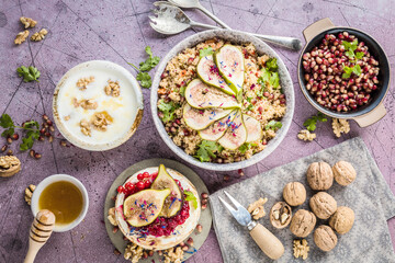 top view of gourmet dish with Figs fruits, nuts, honey, couscous and pomegranate seeds on table