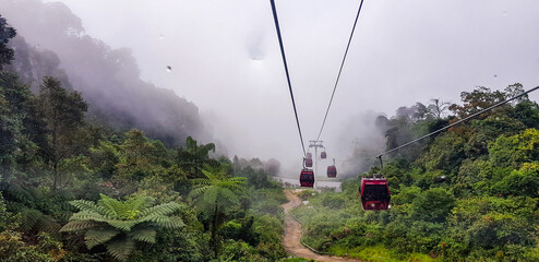 cable car at genting highlands, malaysia in a foggy weather with green grass visible from inside...