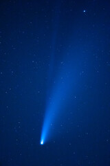 Trace of a comet or shooting star in a blue starry sky with stars in the night. Astronomy or Christmas background.