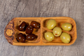 black and green olives with olive branch on a wooden board