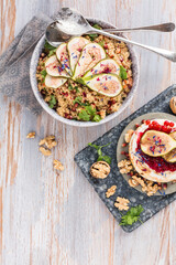 top view of gourmet dish with Figs fruits, nuts, honey, couscous and pomegranate seeds on table