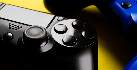 Blue and black gamepads on a yellow background